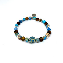 Cargar imagen en el visor de la galería, OCHRANA Pulsera elástica de 17.5 cm de piedra de jaspe y sedimento azul, ojo de tigre mate y hematita plateada con calavera de cerámica
